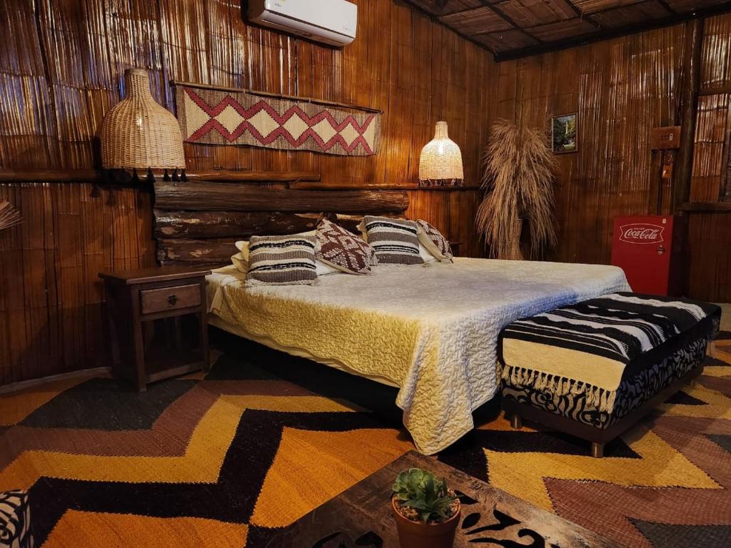 a bedroom with a bed in a room with wooden walls at Posada Turistica Rural y Glamping Altos del Dorado La Mesa in La Mesa