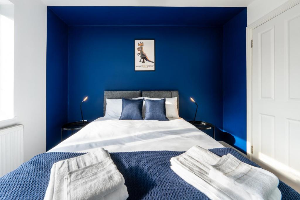 um quarto azul com uma cama com paredes azuis em Modern Apartment In Central Watford by Hampton - Ideal For Professionals & Contractors em Watford