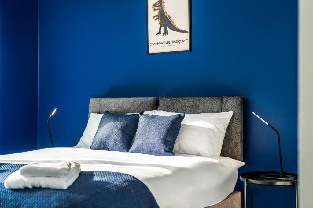 a blue bedroom with a bed with a dinosaur picture on the wall at Modern Apartment In Central Watford by Hampton - Ideal For Professionals & Contractors in Watford