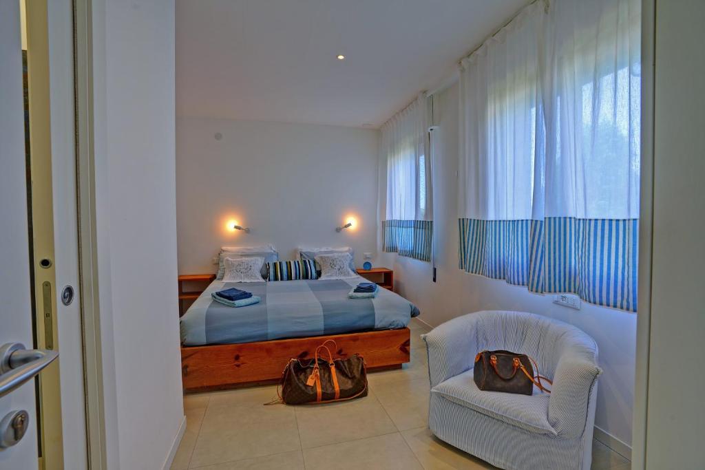 1 dormitorio con 1 cama y 1 silla con bolsa en Alba Apartment, en Spinea