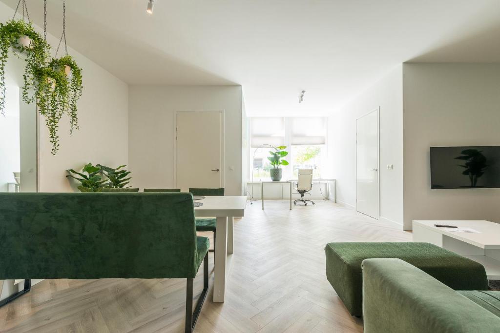 sala de estar con sofá verde y mesa en New Luxurious Apartment With 2 Bedrooms & Garden, en Roosendaal