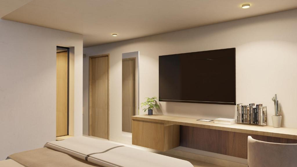 uma sala de estar com uma televisão de ecrã plano na parede em Jules & Laurent Hotel Contemporaneo em Ensenada