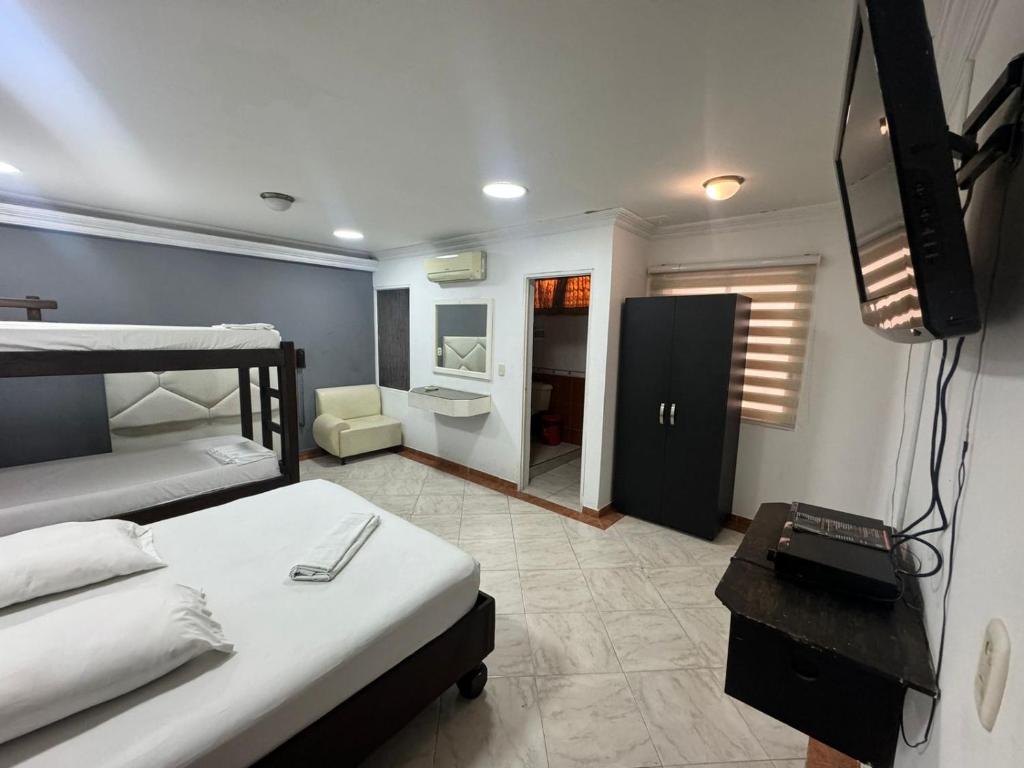 a bedroom with two beds and a television in it at HOTEL PLAZA REAL SUR in Cali