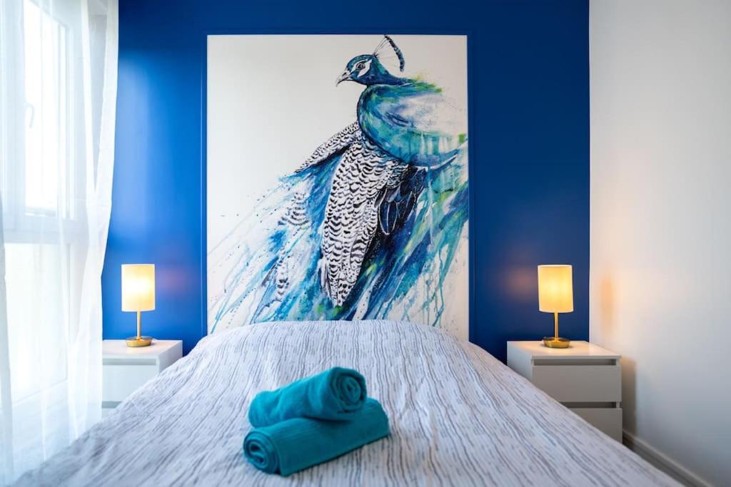 un lit avec deux serviettes bleues dessus dans l'établissement Envole - moi, à Mont-Saint-Aignan