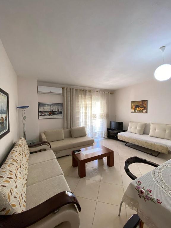 a living room with two couches and a table at Alvi Apartment 1 in Sarandë