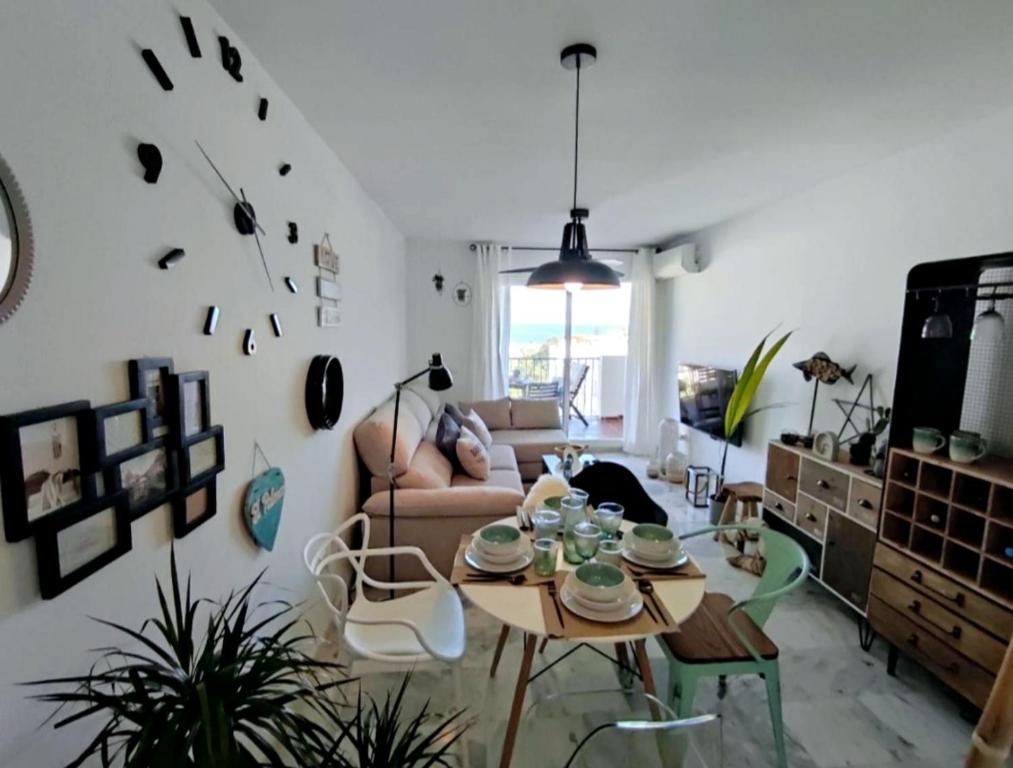 ein Wohnzimmer mit Tisch und Couch in der Unterkunft APARTAMENT MIJAS BEACH, ÁNGEL in La Cala de Mijas