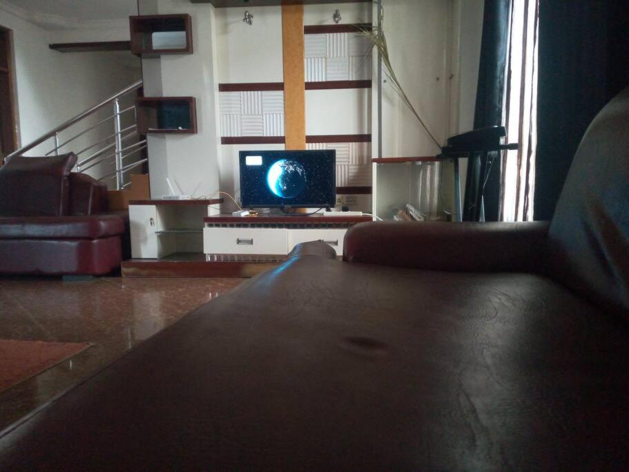 sala de estar con sofá y TV en Home sweet home, en Dar es Salaam