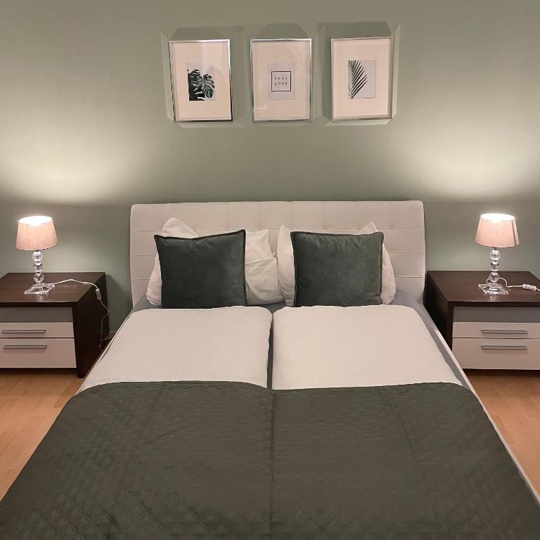 a bedroom with a large bed with two tables and two lamps at Großes 2-Schlafzimmer Apartment in Cölbe in Cölbe