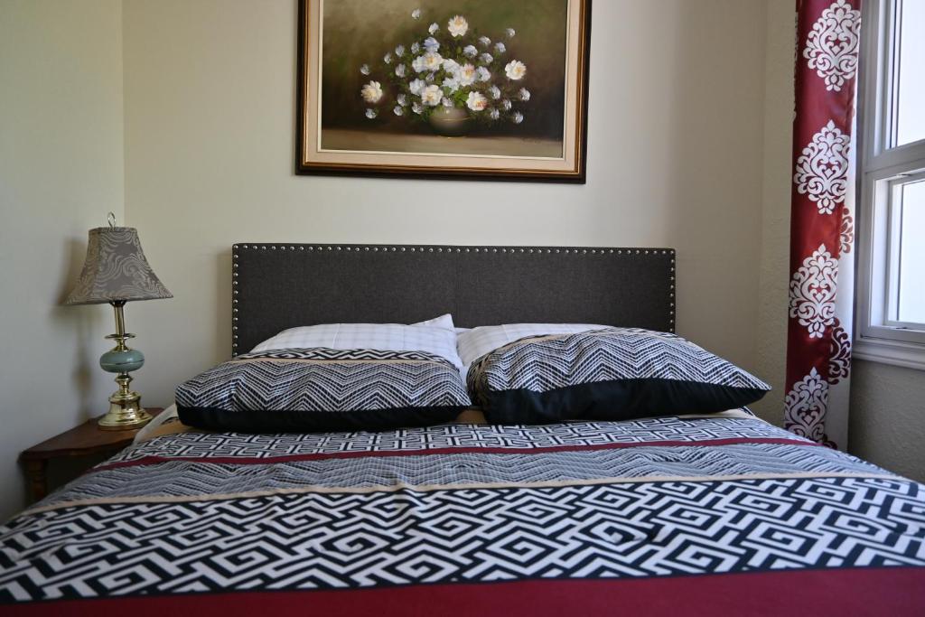 1 dormitorio con 1 cama con 2 almohadas en Centennial Suite, en Niagara Falls