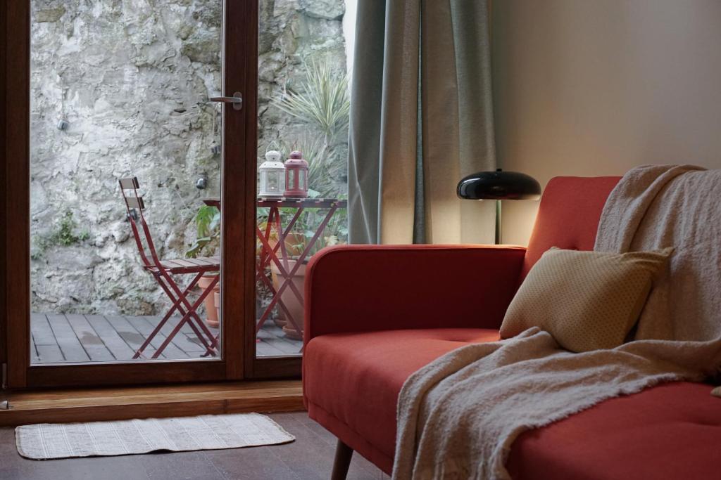 a living room with a red couch and a sliding glass door at 14 Calçada de Santiago in Vila do Conde