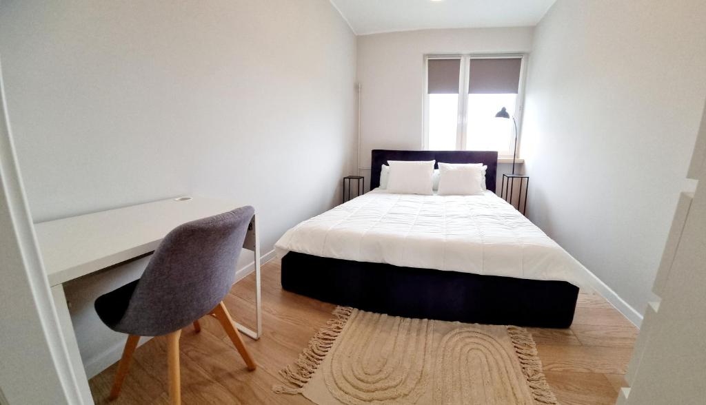 - une chambre avec un lit, un bureau et une chaise dans l'établissement Apple Apartments - Atlas Arena, Zoo, Fala, Mandoria, lotnisko, parking, à Łódź