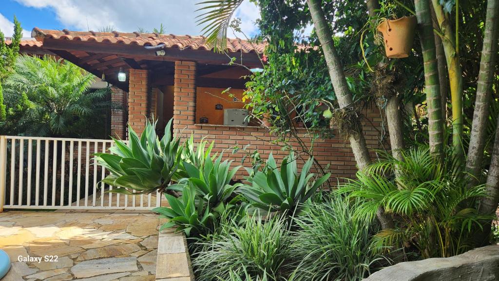 a brick house with a garden with plants at Área de Lazer com quartos e cozinha aberta na Chácara Refrigerio in Salto