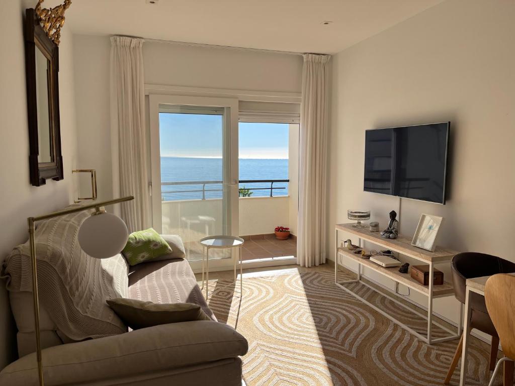 a living room with a couch and a television at Sinfonía Azul vistas al mar in Estepona