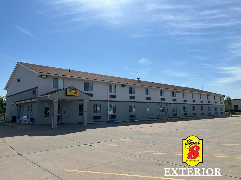 an exterior view of a large white building at Super 8 by Wyndham Emporia in Emporia