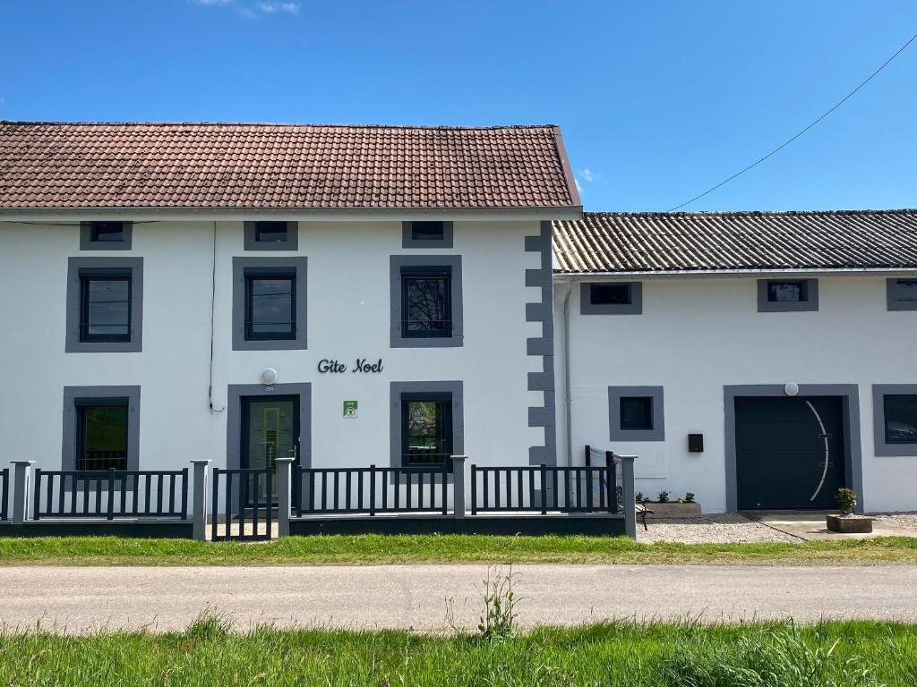 Ein weißes Gebäude mit einem Zaun davor. in der Unterkunft Gîte Plombières-les-Bains, 4 pièces, 5 personnes - FR-1-589-432 in Plombières-les-Bains