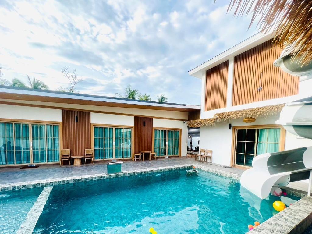 a swimming pool in front of a house at Villa De Phawa in Samut Songkhram