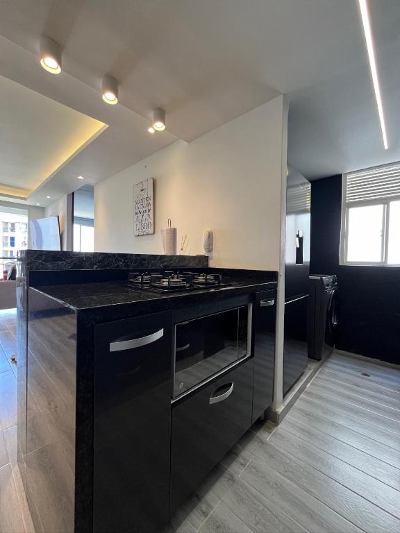 a kitchen with a black counter and a stove at Kevin Apartamento Moderno en Cali in Cali