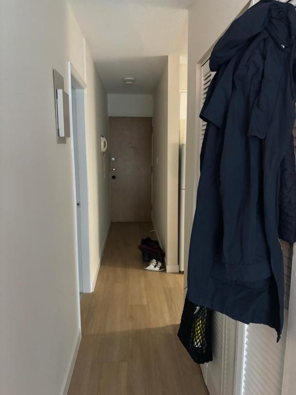 un pasillo con un abrigo azul colgando de una puerta en Cosy Living: Your Private Urban Retreat, en Vancouver