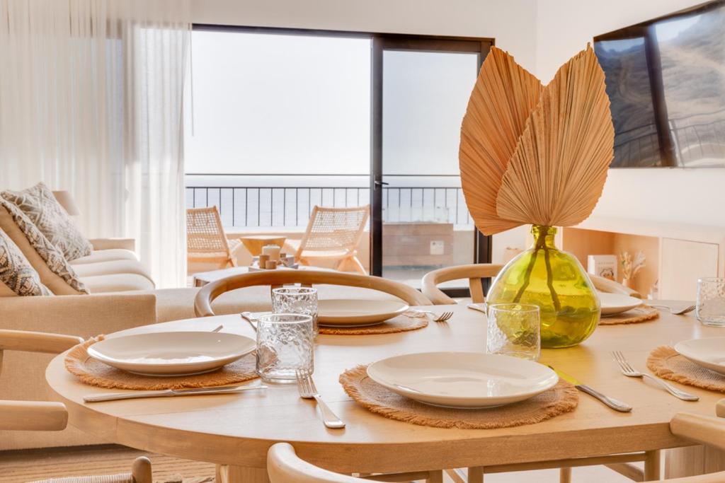 mesa de comedor con platos blancos y jarrón amarillo en Gavilan Villa, en El Pescadero