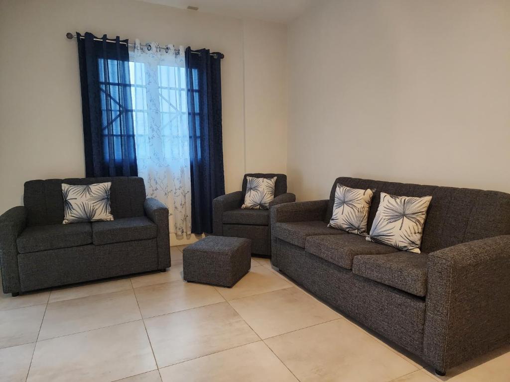 a living room with two couches and two chairs at Robinson Villa..... your gateway to Carnival City. in Belmont