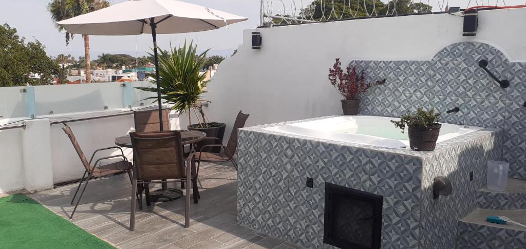 a tub on a patio with a table and chairs at Aparta-Hotel CASA REAL Apartamentos in Chapala