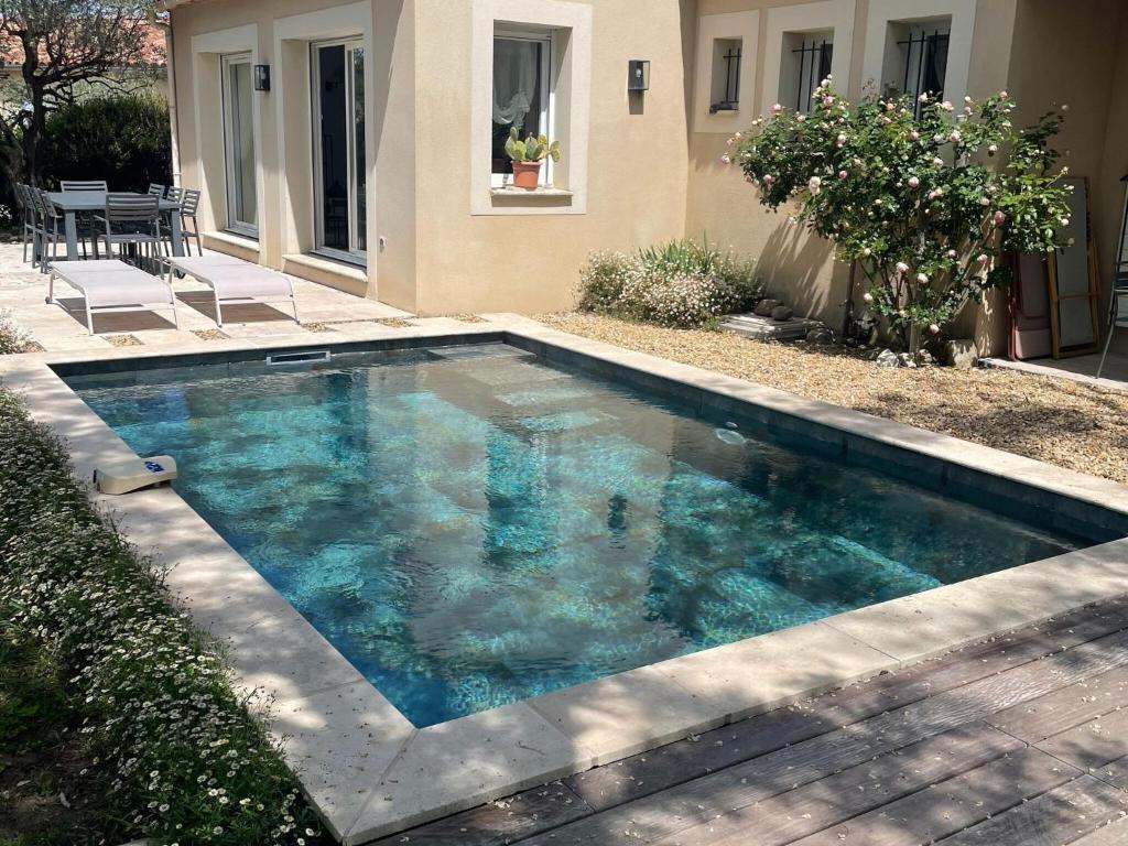 une piscine avec de l'eau bleue devant une maison dans l'établissement Holiday Home Vaison with Private Pool, à Vaison-la-Romaine