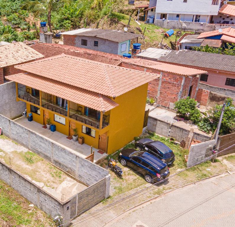uma casa amarela com um carro estacionado em frente em Chalés Oliveira em Ilhabela