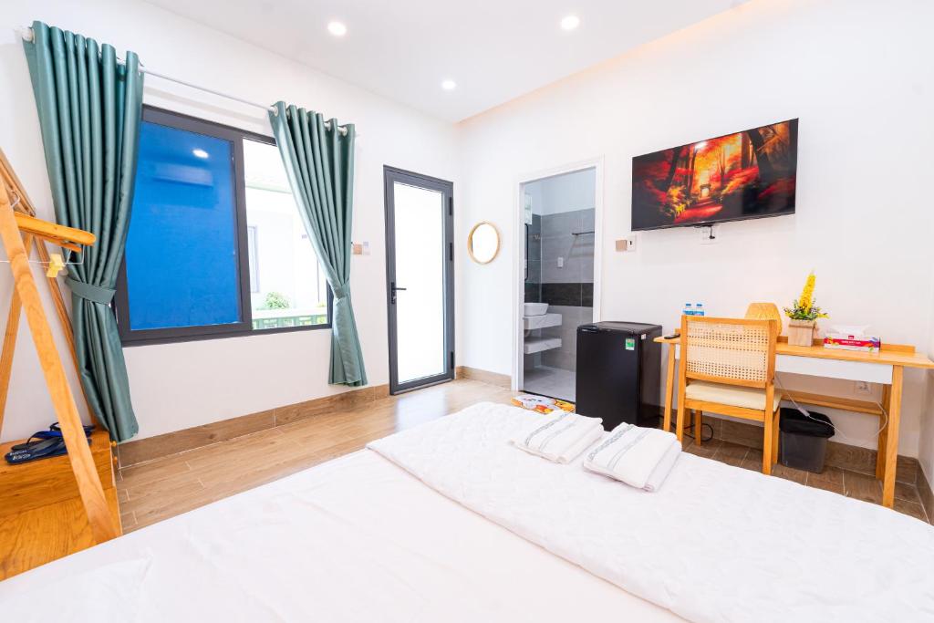 a bedroom with a desk and a bed and a table at Nine Homestay in Can Tho