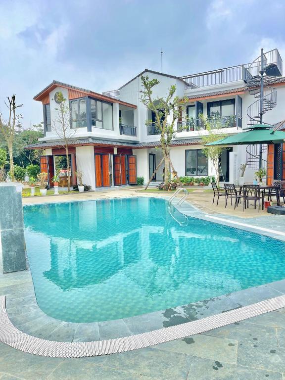 a swimming pool in front of a house at AKIRA VILLA _ Venuestay in Ba Vì