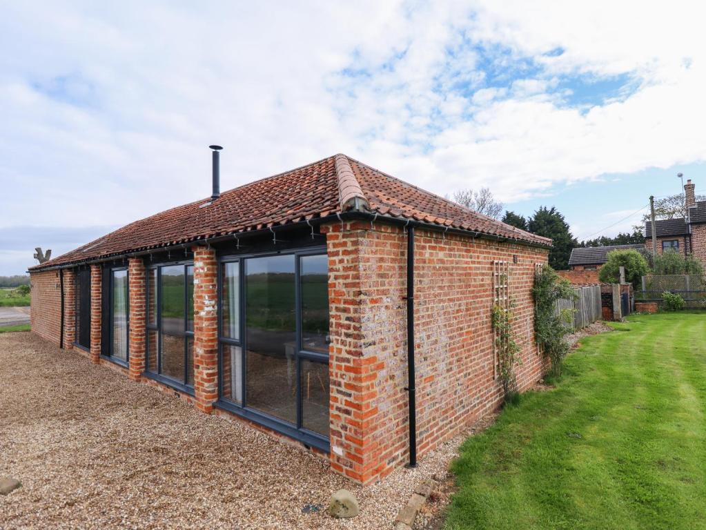 an extension to a brick house with glass windows at Little Owl in Market Rasen
