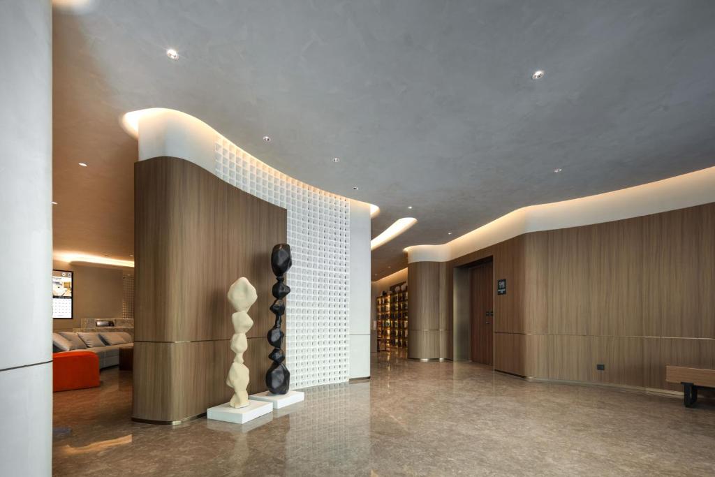 a lobby with a staircase with a sculpture in the middle at Atour Hotel Ningbo Cixi Ancient Town in Ningbo