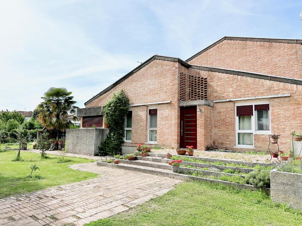 a brick house with a staircase leading up to it at Villa Yemaya - camera con bagno privato in Casarsa della Delizia