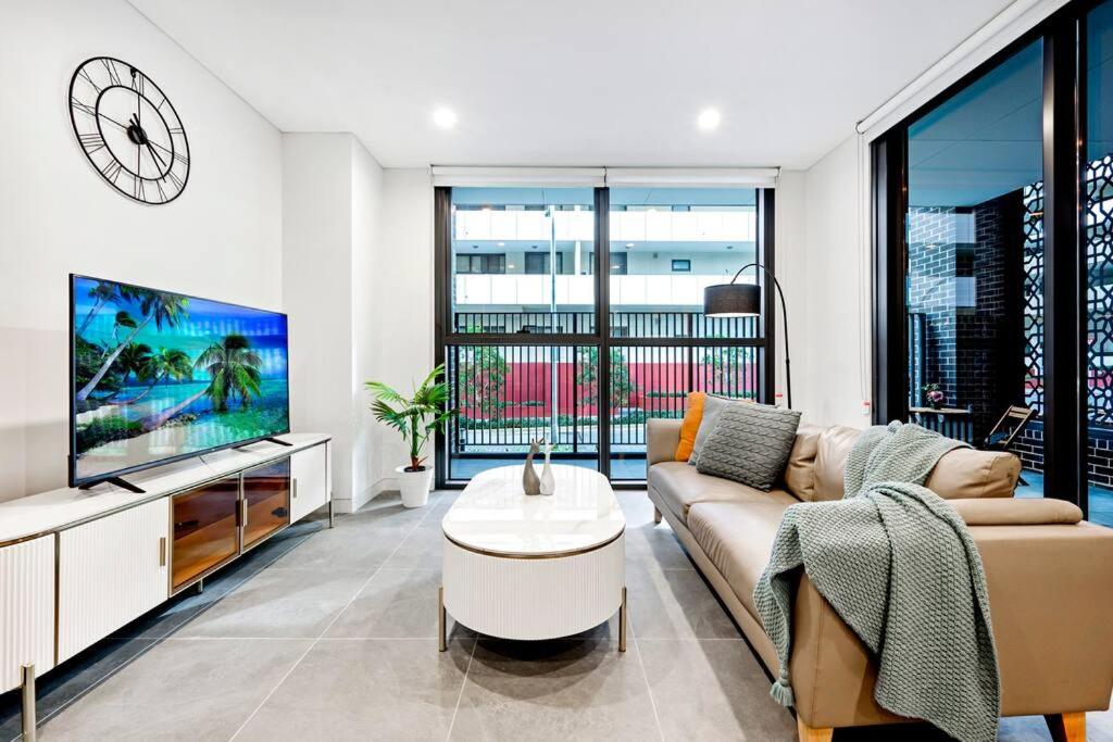 un soggiorno con divano e TV di Comfy 1 Bedroom in Homebush a Sydney