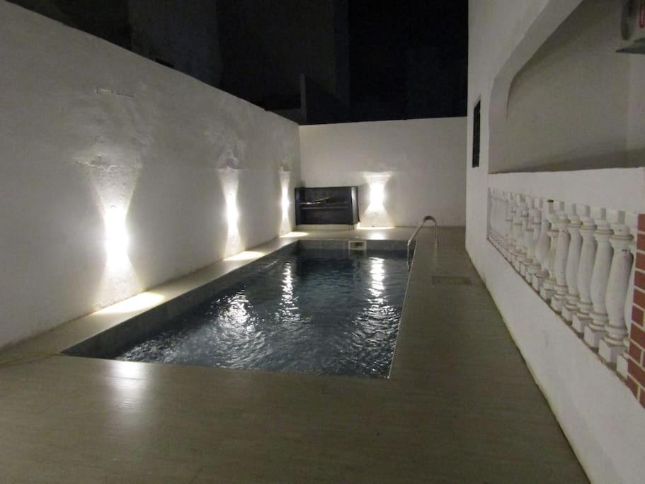 a room with a pool of water with a fireplace at Villa Dakar 200 m plage in Dakar