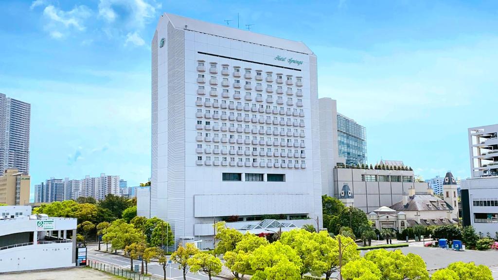 a tall white building with trees in front of it at Hotel Springs Makuhari in Chiba