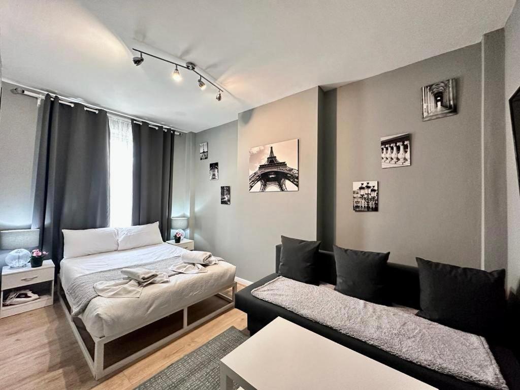 ドバイにあるDubai Media City Convenient Apartmentsのベッド1台とソファが備わる小さな客室です。