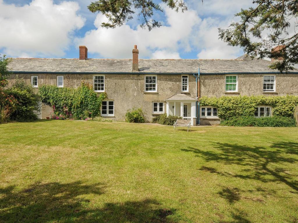 an old stone house with a large yard at Lee Barton Farmhouse in Bude