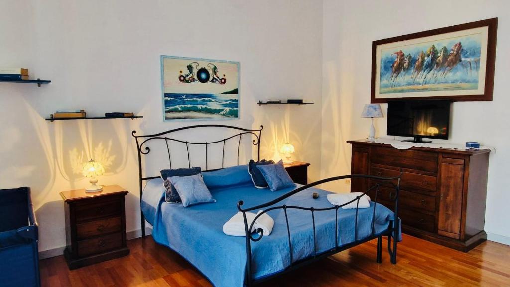 ein Schlafzimmer mit einem blauen Bett und zwei Nachttischen in der Unterkunft La Casa di Geo Stazione Centrale La Spezia 5 Terre in La Spezia