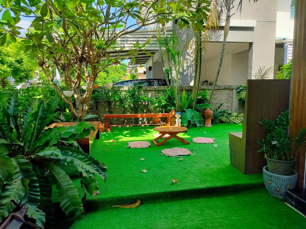 un jardín con banco y césped verde en Friend's House en Bangkok