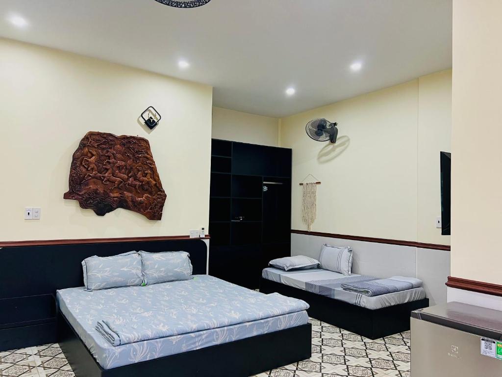 Zimmer mit 2 Betten und einer Wand in der Unterkunft SAM HOMESTAY HUE in Hue