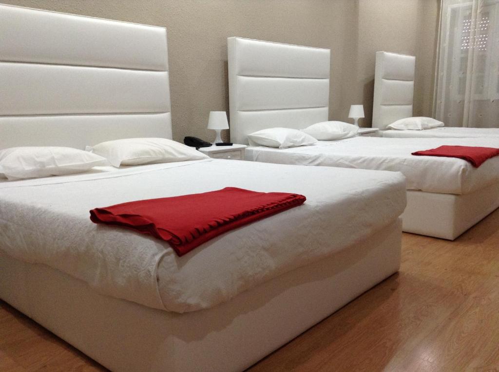 1 dormitorio con 2 camas y toallas rojas. en Royal Porto City, en Oporto