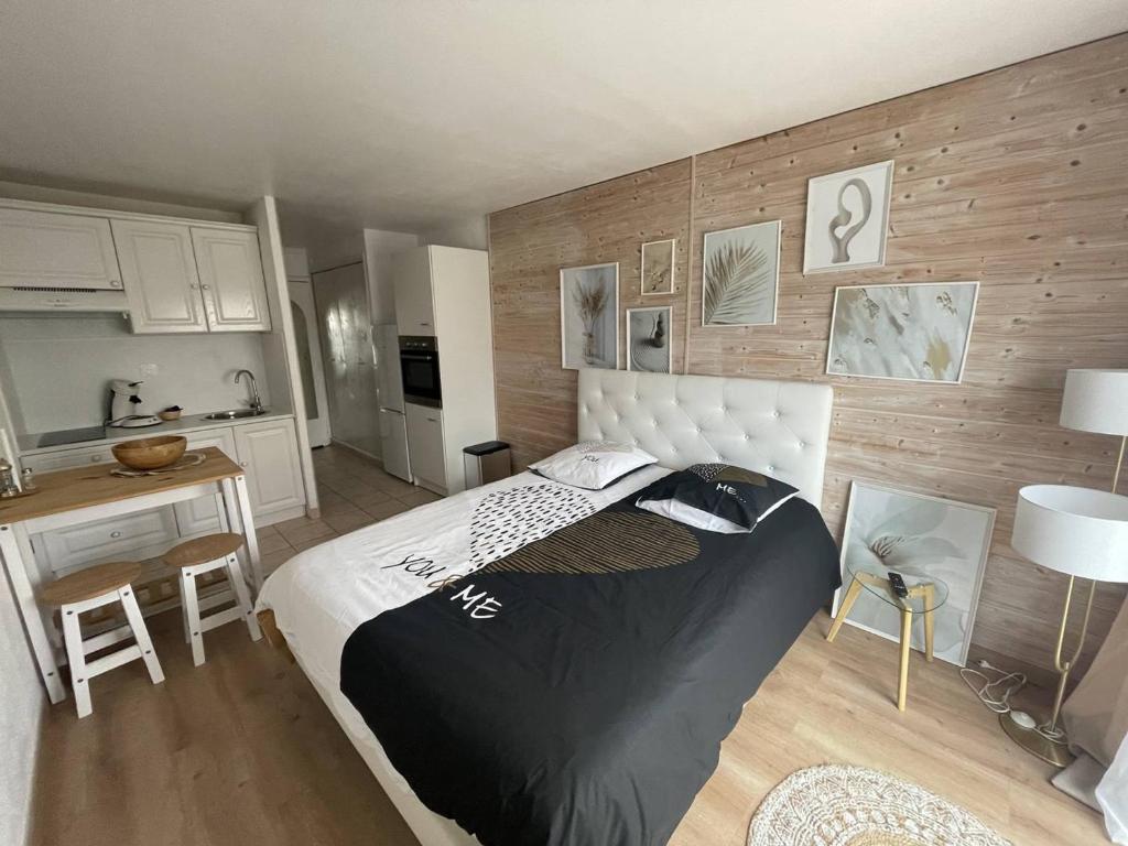 une chambre avec un grand lit et une cuisine dans l'établissement Studio rénové au centre port, à 2 min des commodités et proche plage - FR-1-723-154, au Cap d'Agde