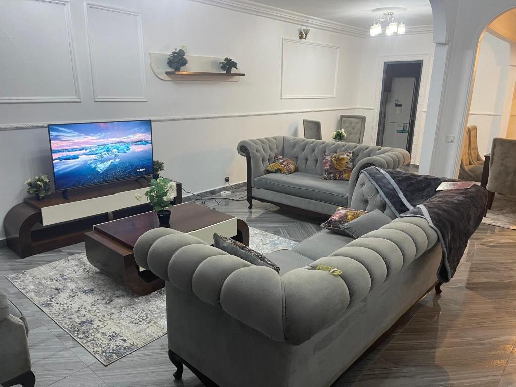 uma sala de estar com 2 sofás e uma televisão de ecrã plano em Danin Real-estates em Douala