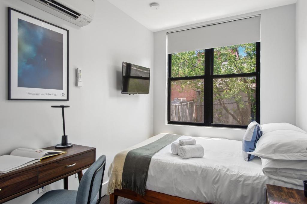 1 dormitorio con cama, escritorio y ventana en 4 Peeps Charm Apartament in Williamsburg Brooklyn NYC, en Union City