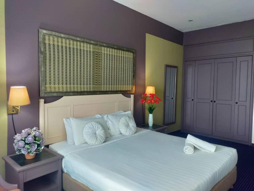 a bedroom with a large white bed with flowers on it at Jazz Rainbow Paradise beachfront Peanag in Tanjung Bungah