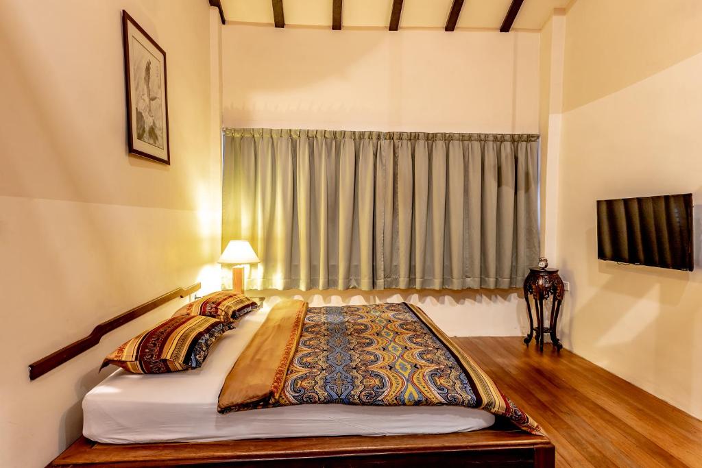 a bedroom with a large bed with a window at Palm Mansion Boutique Suites in George Town