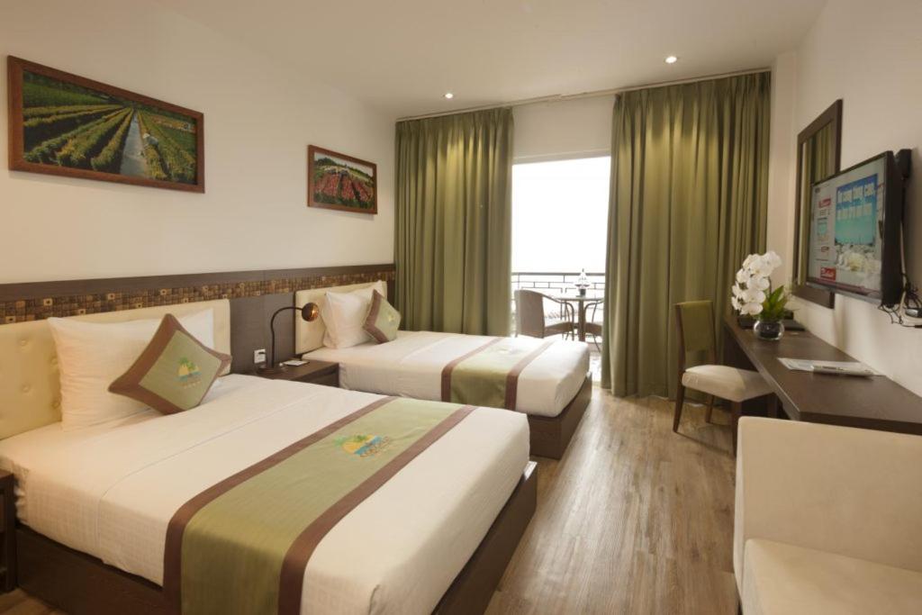 um quarto de hotel com duas camas e uma secretária em Ben Dua em Chợ Giồng Trôm