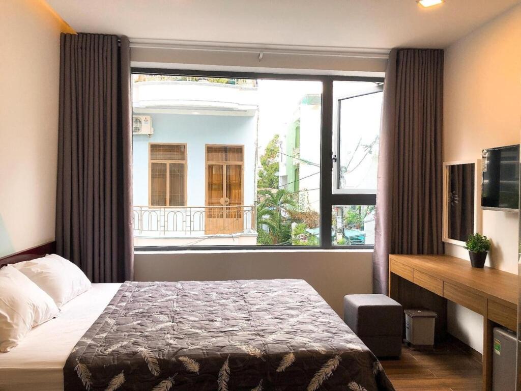 1 dormitorio con cama y ventana grande en Emeral Hotel Nha Trang - by Bay Luxury en Nha Trang