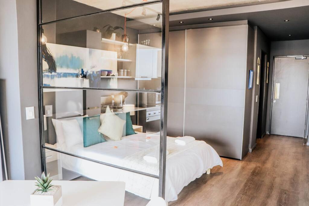 Zimmer mit einem Bett mit Glaswand in der Unterkunft Modern Wex 831 in Kapstadt