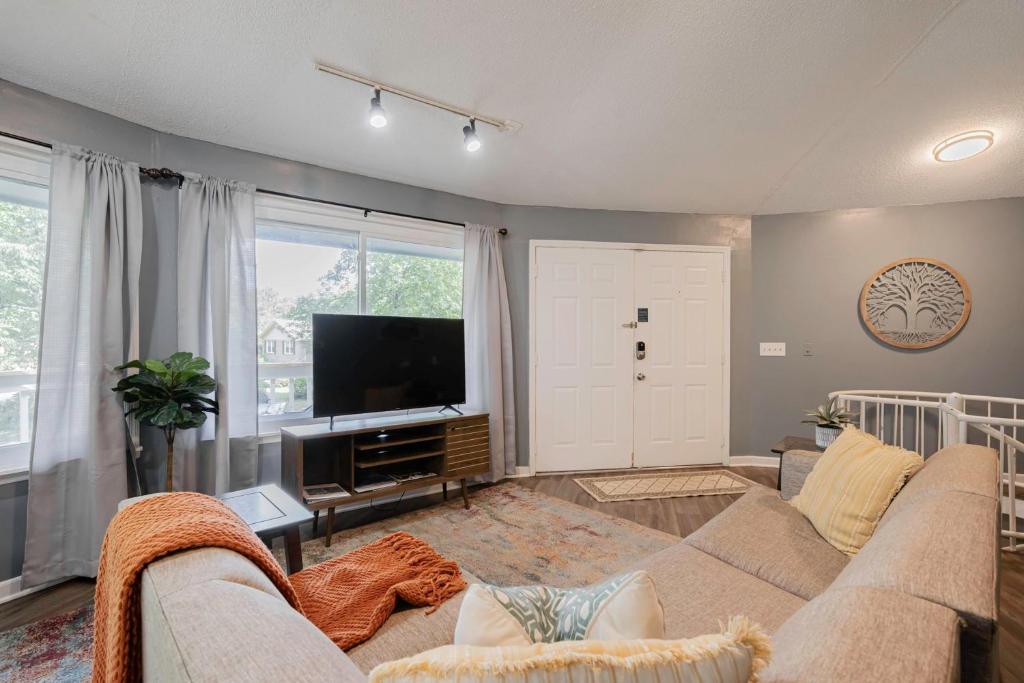 ein Wohnzimmer mit einem Sofa und einem Flachbild-TV in der Unterkunft Opulent Octagonal Oasis with Spiral Stairs-Minutes to Base in Columbia